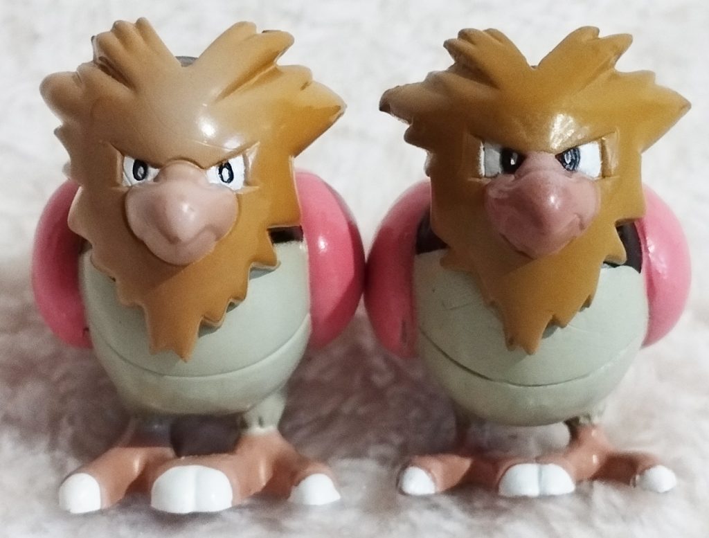 A front view of the Pokémon Tomy figures Spearow; left Auldey variant, right Hasbro variant 