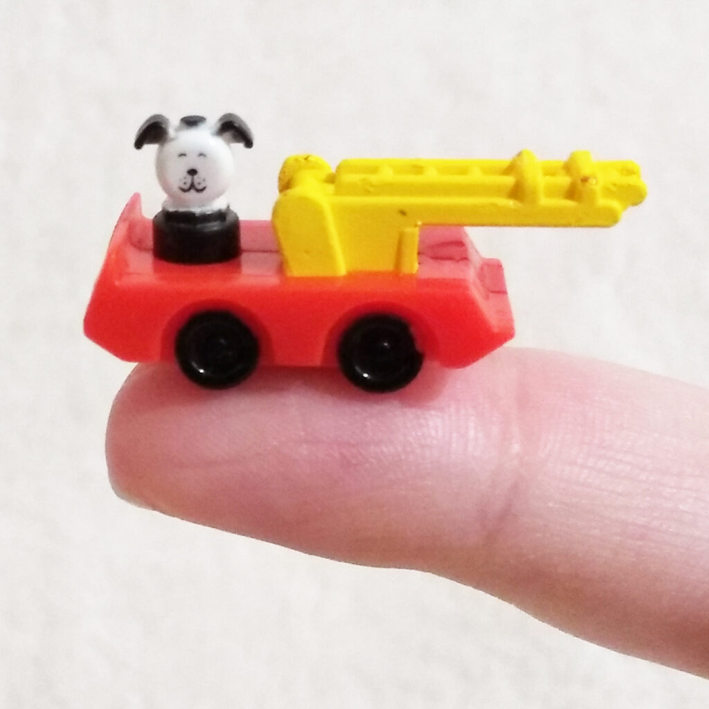 World’s Smallest Micro Toy Box by Super Impulse - Series 1 - Little People - Fire Truck balanced on finger tip