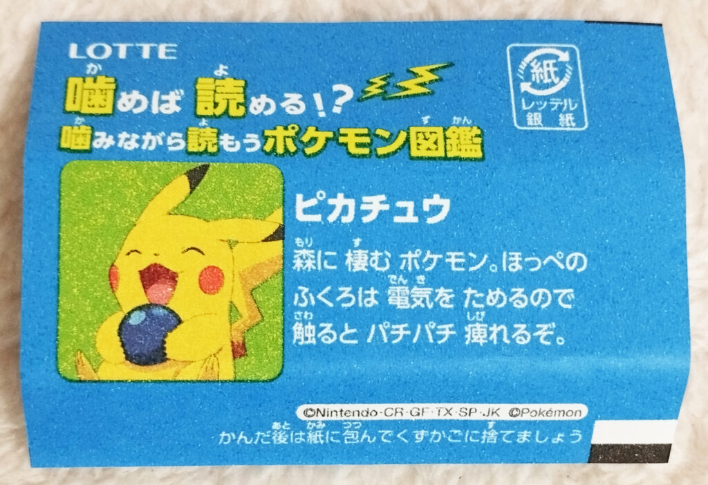 Xylitol Pokemon Chewing Gum Soda Flavour by Lotte - A blue wrapper with an image of a happy Pikachu holding a berry on it with the text in Japanese "Pikachu. A Pokémon that lives in the forest. The bags on its cheeks store electricity, if you touch them, you'll feel numb."