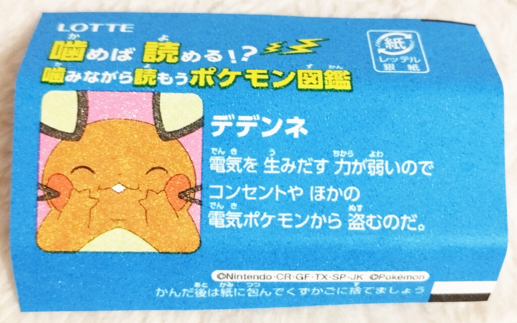 Xylitol Pokemon Chewing Gum Soda Flavour by Lotte - A blue wrapper with an image of a smiling Dedenne on it with the text in Japanese "Dedenne has a weak ability to generate electricity, so it steals it from electrical outlets and other electric Pokémon."
